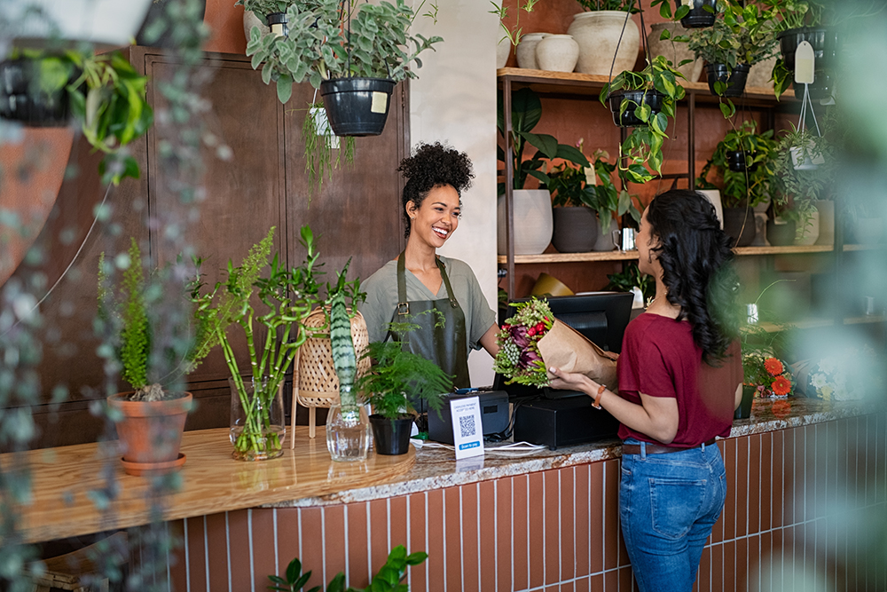 Small business flower shop owner and customer talking